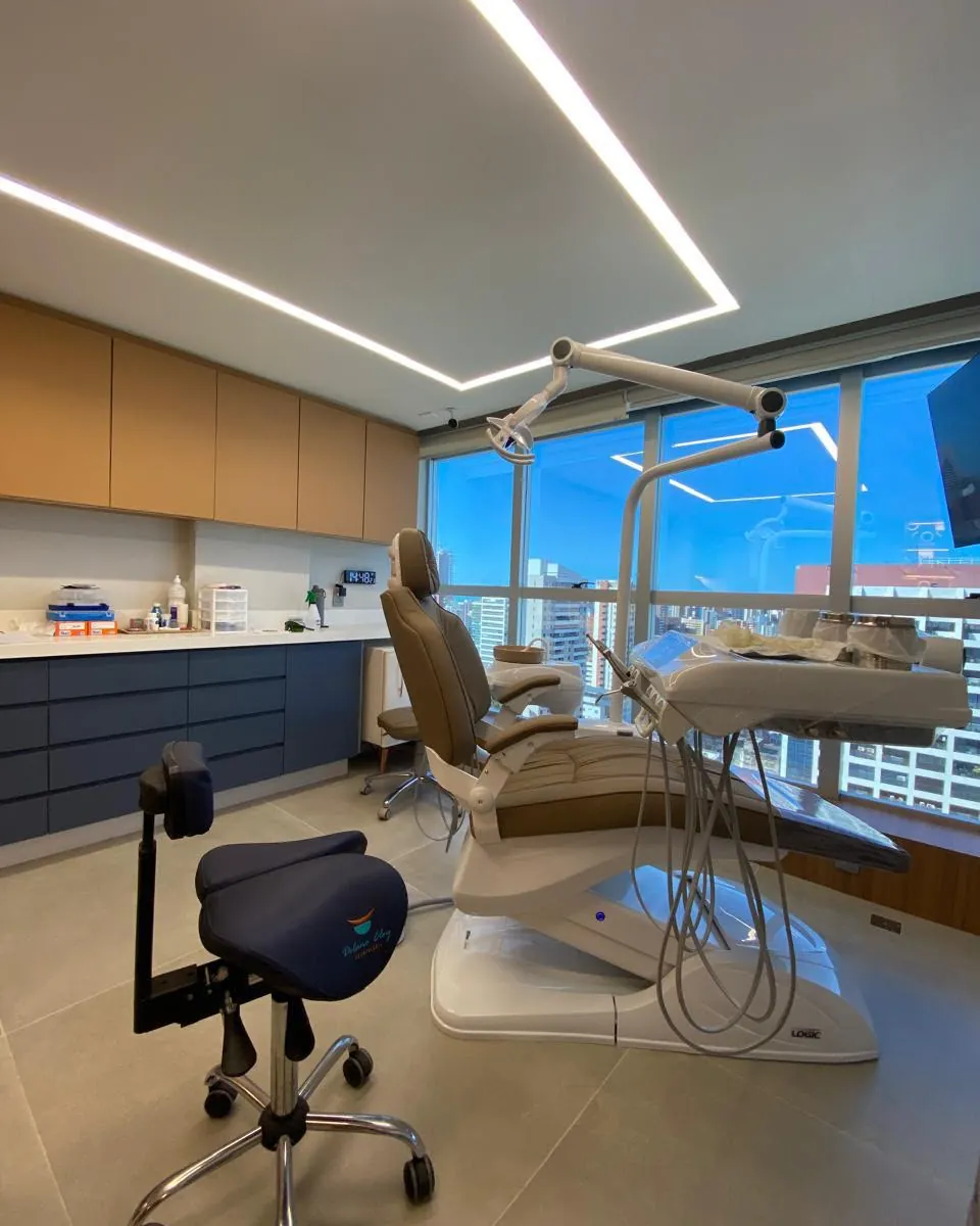 Consultório odontológico entregue pela RICCO, com marcenaria sob medida, iluminação linear e vista para o mar.