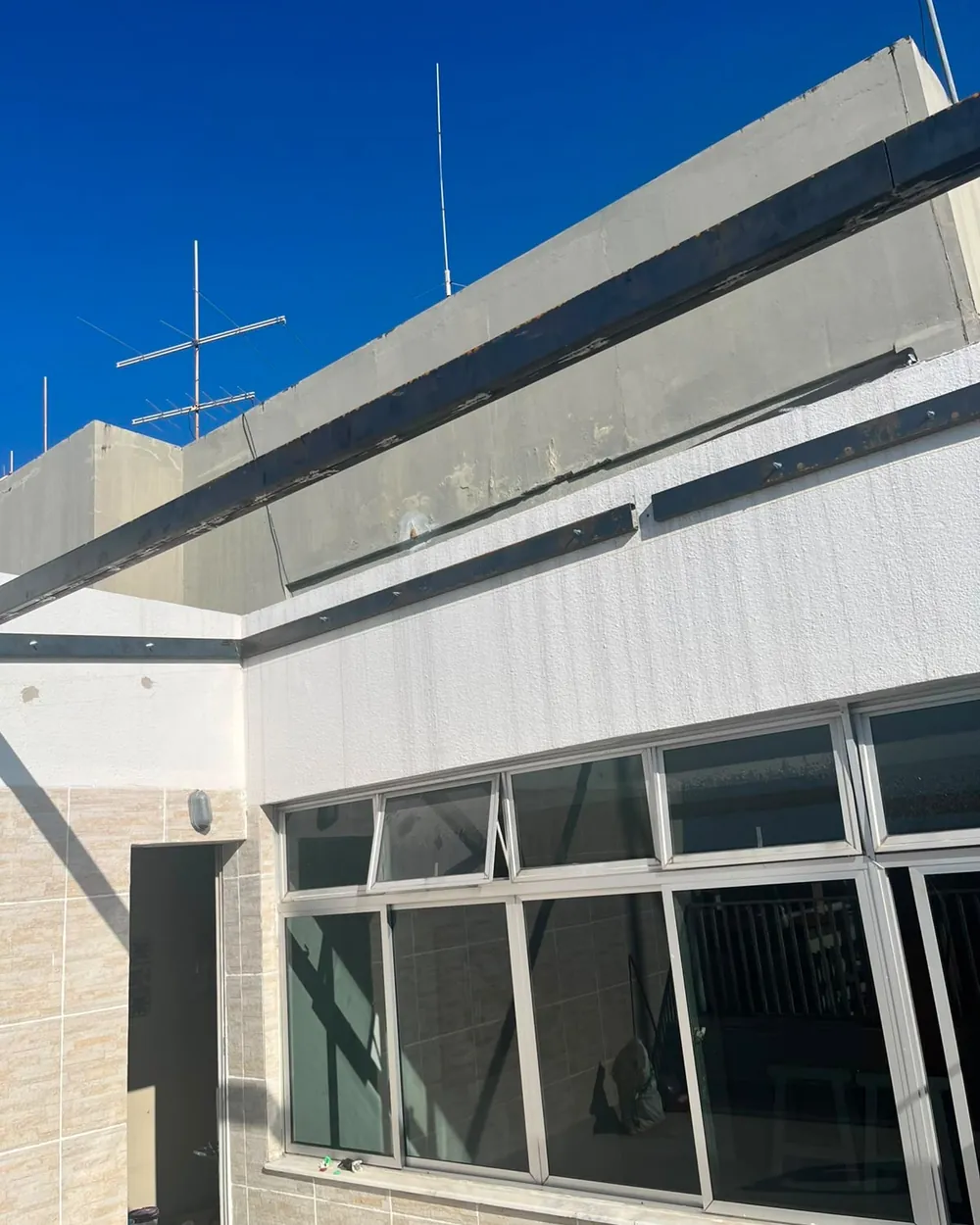 Fachada de edifício corporativo com brises horizontais e caixilharia em alumínio, executada pela RICCO.