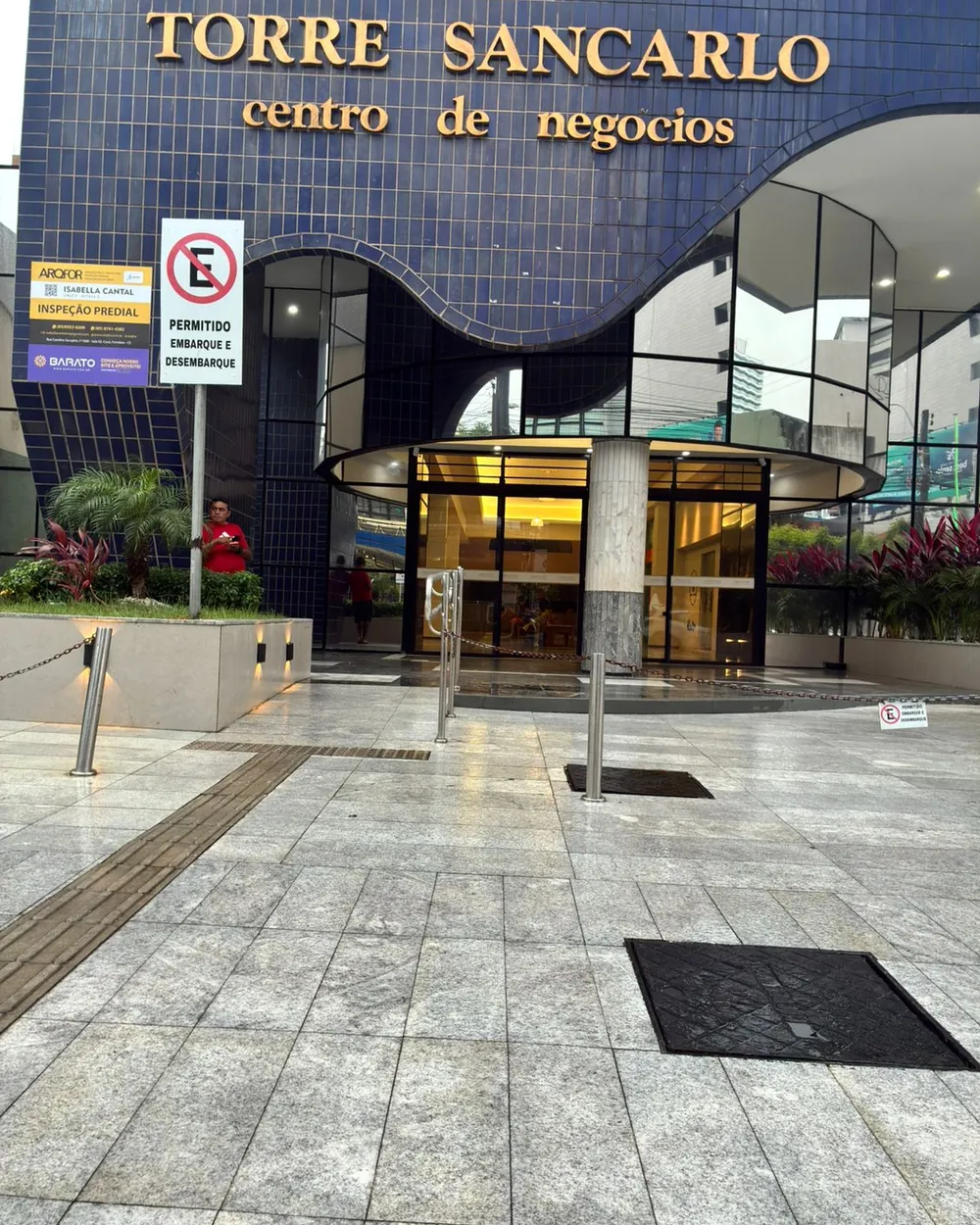 Entrada da Torre Sancarlo, com fachada curva em pastilha azul e piso em granito.